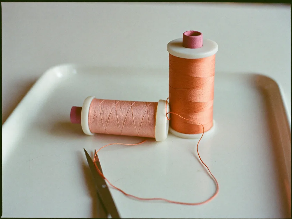 Spools of cotton thread on a clean pale tray