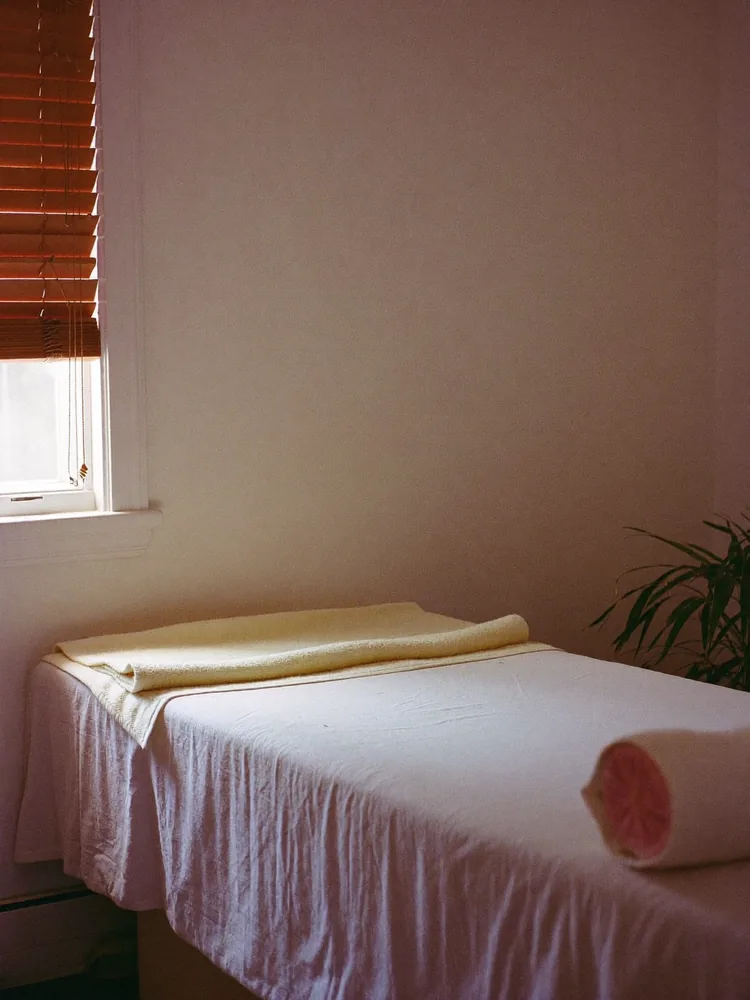 Treatment couch made up with a fresh towel under soft window light