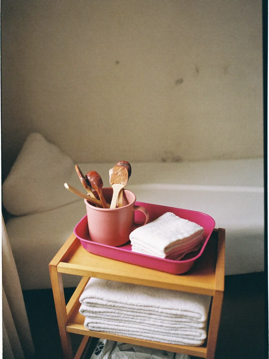 Folded towels and a warm wax pot beside a treatment couch